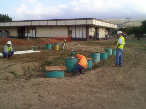 Three workers installing wastewater treatment